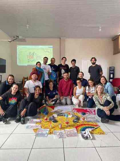Turma 01 de Assis reunida diante da identidade visual do EdPopRua no primeiro encontro presencial